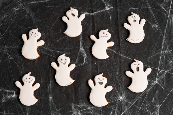 Cookies in Form of Ghosts on Table with Halloween Cobweb